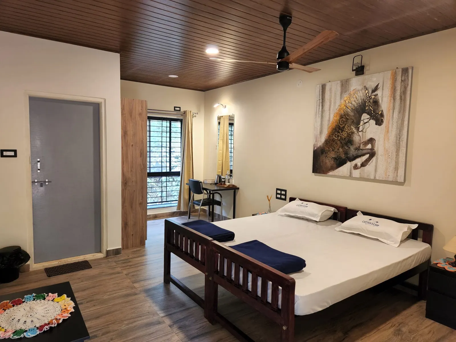 Inside an Executive Cottage — twin beds, ceiling fan, and a balcony